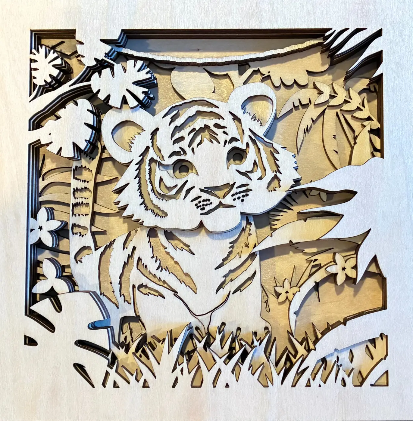 Six unpainted wooden layers assembled to show the baby tiger design